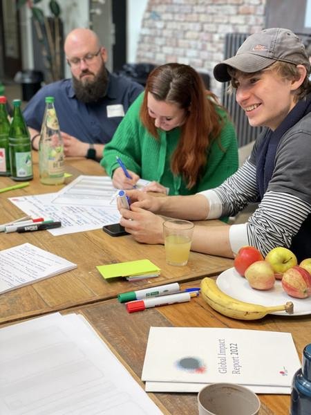 Junge Menschen an einem Tisch, die an Ideen arbeiten